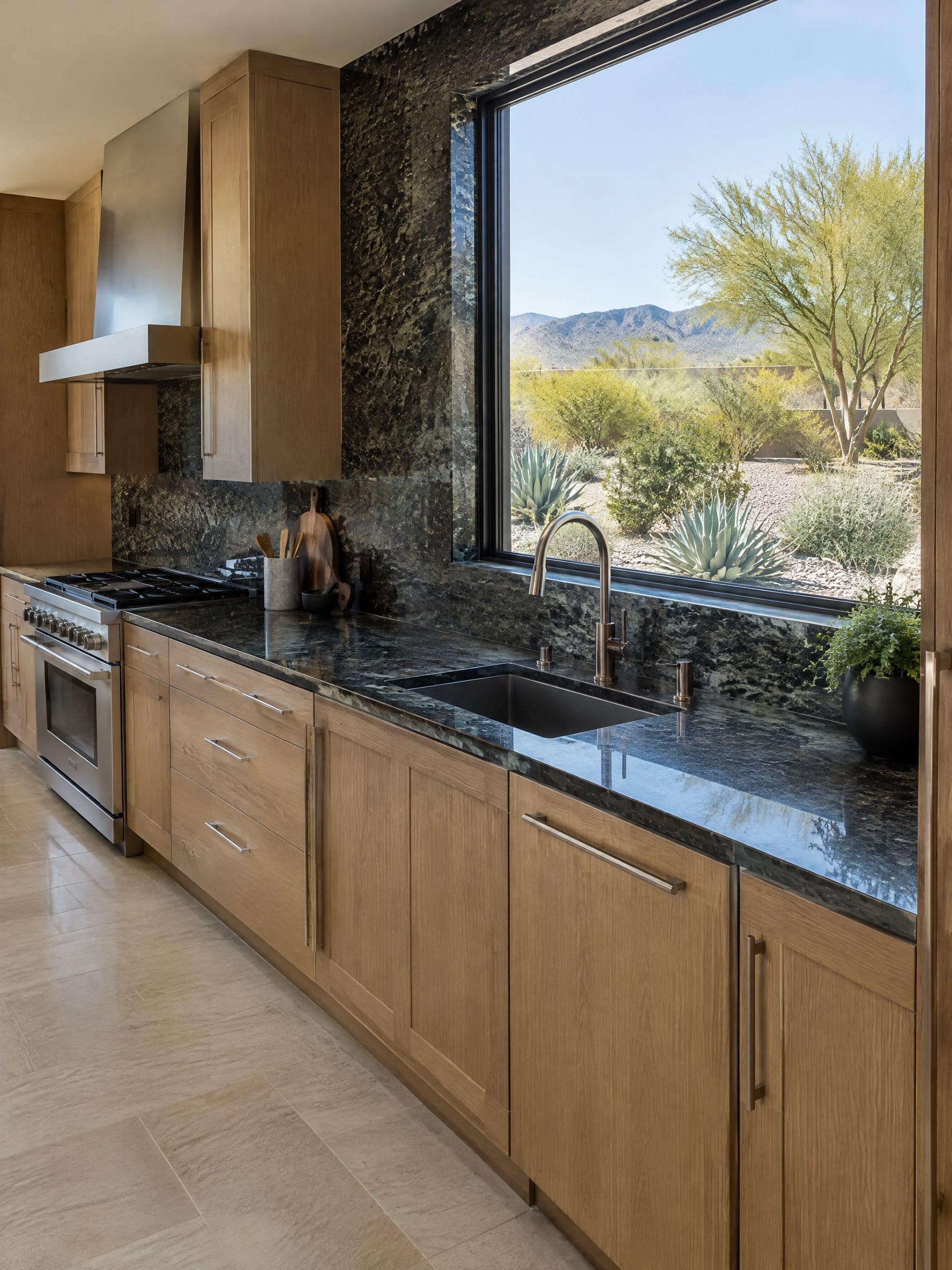 Kitchen perimeter in polished dark granite with a full-height matching slab backsplash